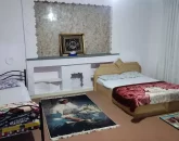 دو تخت خواب با روتختی سفید و فرش کوچک اتاق خواب آپارتمان در بندر عباس