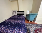 تخت خواب با روتختی آبی و میز آرایش اتاق خواب آپارتمان در بندرلنگه