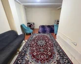 تخت خواب با روتختی آبی و صندلی و مبل سرمه ای رنگ اتاق خواب آپارتمان در بندرلنگه