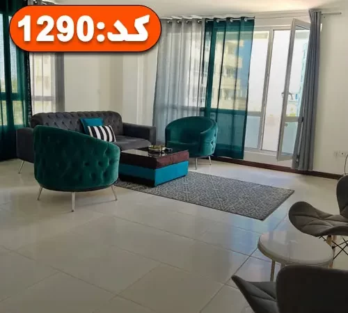 صندلی و مبلمان طوسی و سبز رنگ و در رو به تراس سالن نشیمن آپارتمان در بندر عباس