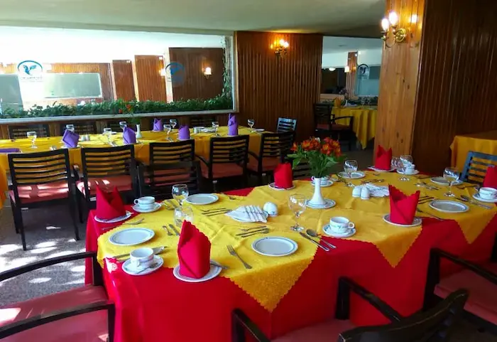 رستوران هتل فانوس بندرعباس ونمای داخلی آن چیده شده با میز و صندلی های زرد و قرمز 454464