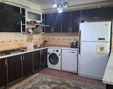 آشپزخانه با کابینت های مشکی، یخچال، لباسشویی آپارتمان در بندر جاسک 125346