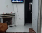 شومینه و اتاق پذیرایی با کفپوش سرامیکی و تلوزیون دیواری آپارتمان در بندرعباس 45844