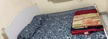 تخت خواب با روتختی آبی اتاق خواب خانه روستایی در بندر جاسک
