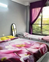 تخت خواب با روتختی رنگی و پنجره بزرگ رو به محوطه سرسبز اتاق خواب ویلا در بندر عباس