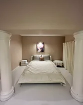 تخت خواب با روتختی سفید رنگ و میز عسلی اتاق خواب ویلا در بندر لنگه